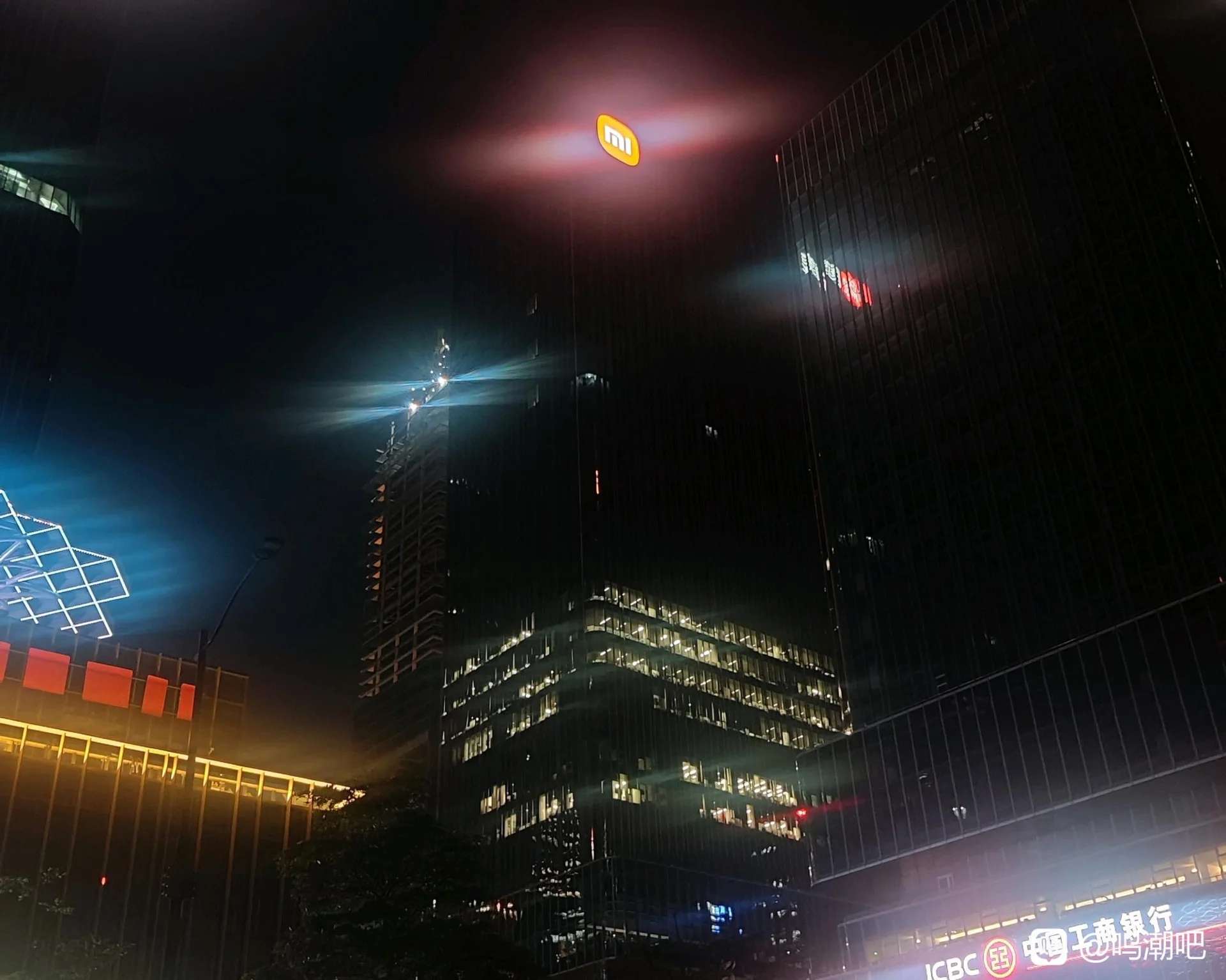 A nighttime view of the Guangzhou Xiaomi Internet Industry Park, with the Kuro Games logo visible and many office windows lit.